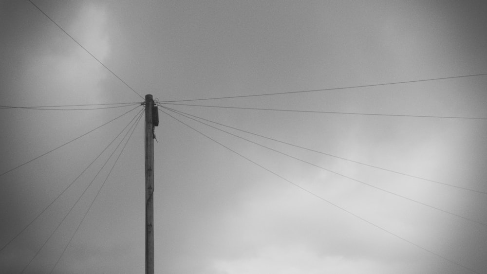 pole with wires under grey cloudy sky