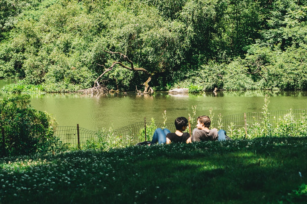 two men sitting on grass field