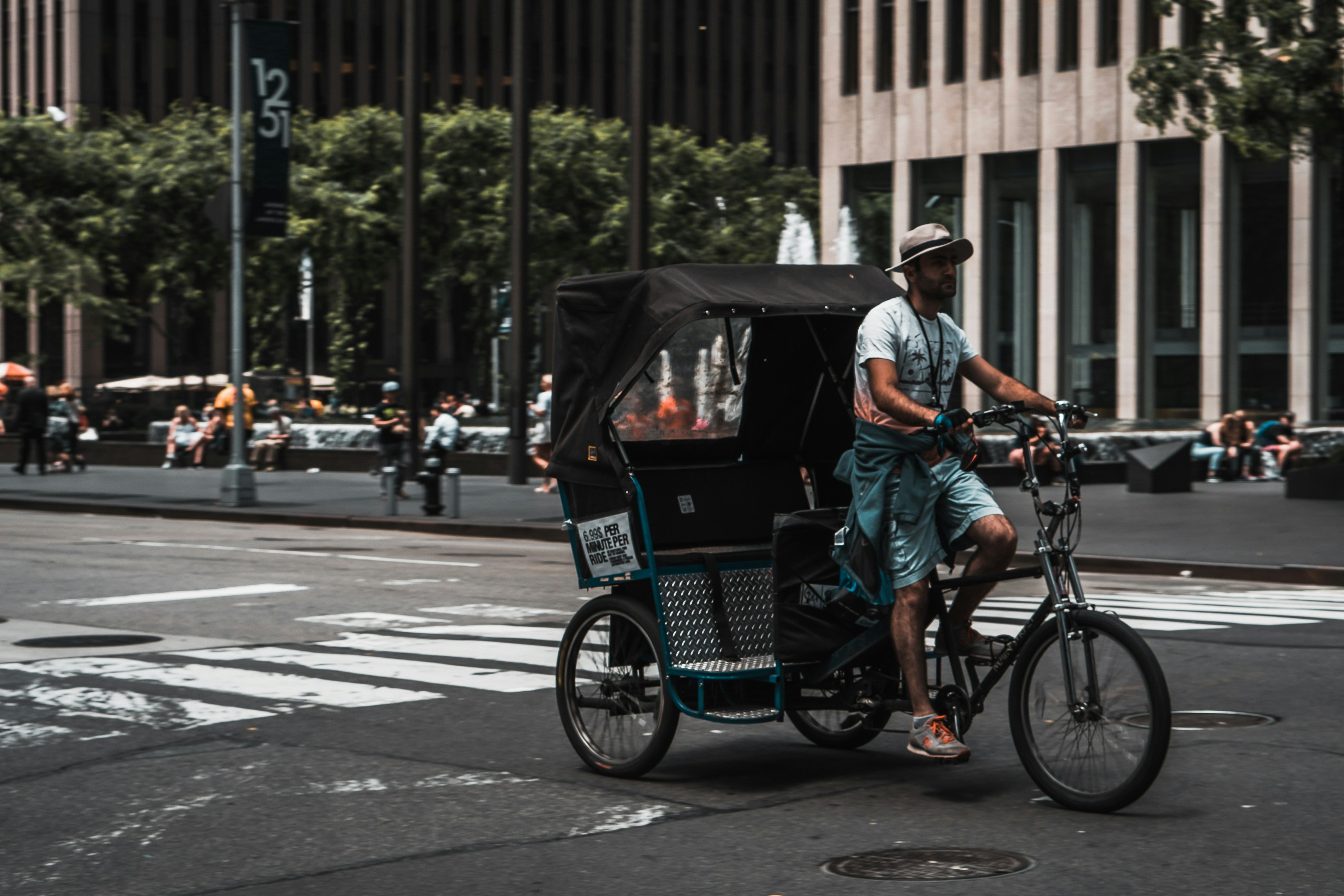 man driving pedal rickshaw on road