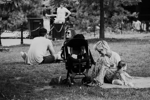 A group of moms chatting happily in a park with their babies