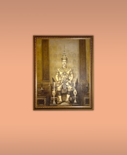 Vintage image of Maharaja Ranjit Singh seated on a decorated throne, adorned with jewels and royal garments.