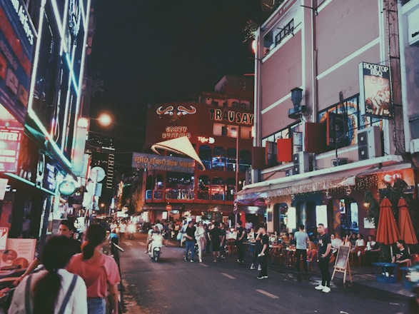 A lively street scene with happy tourists enjoying local food and city sights.