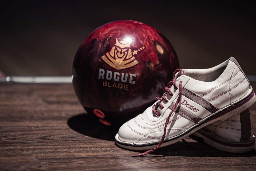 white and grey leather low-top sneaker near red bowling ball