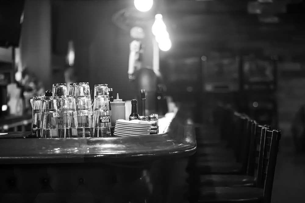 grayscale photo of drinking glass on tables