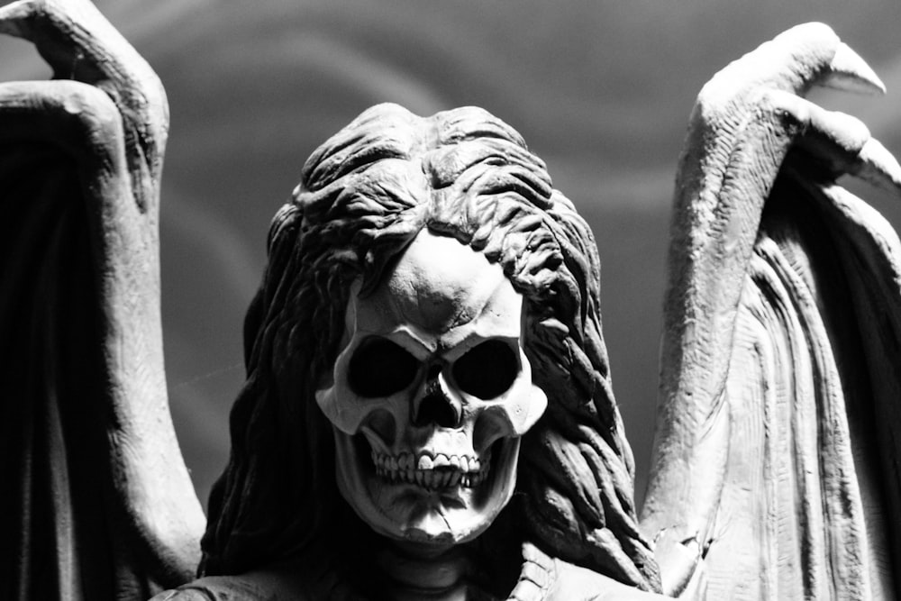 skull-faced human with wings statue