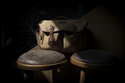 A stylish leather bag resting on a vintage wooden table with soft natural light highlighting its texture.