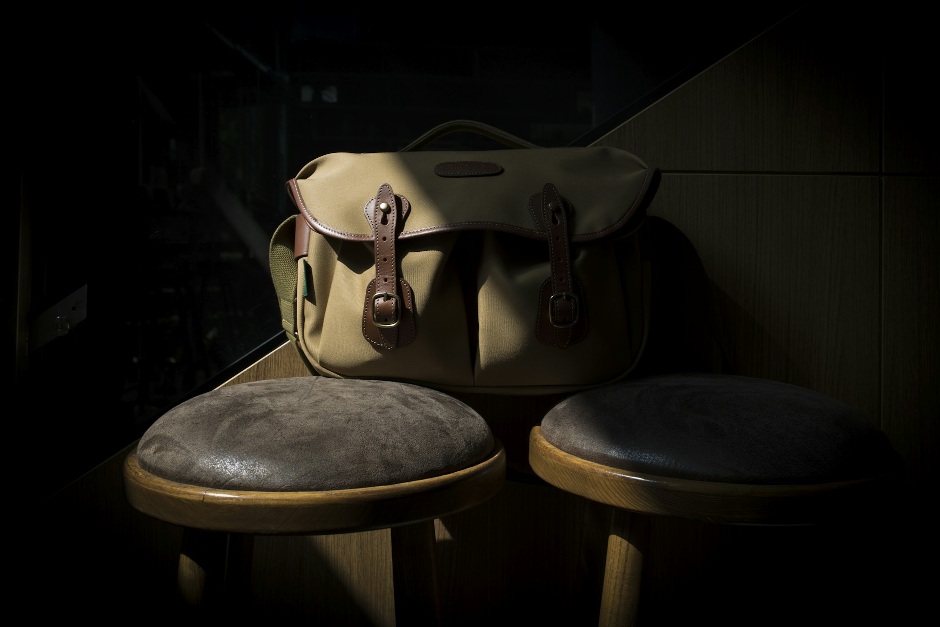 A rustic leather bag resting on a wooden table, bathed in warm afternoon light.