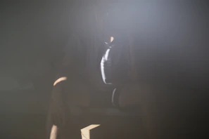 A shadowy figure of a woman in a dimly lit room, hinting at secretive scam activities.