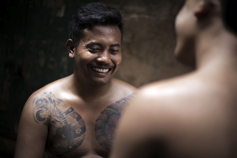 smiling man with tattoos