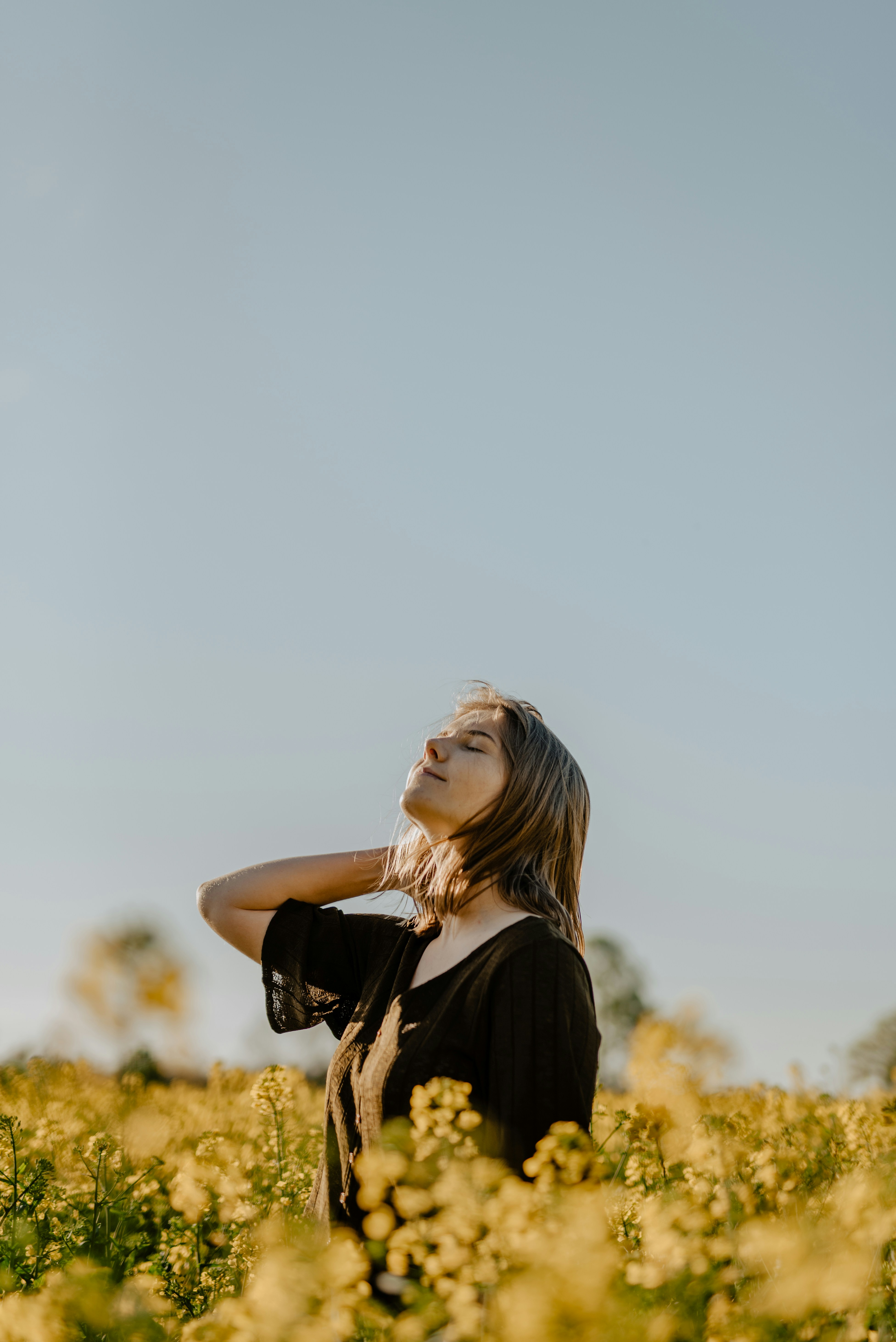woman standing on yellow flower field