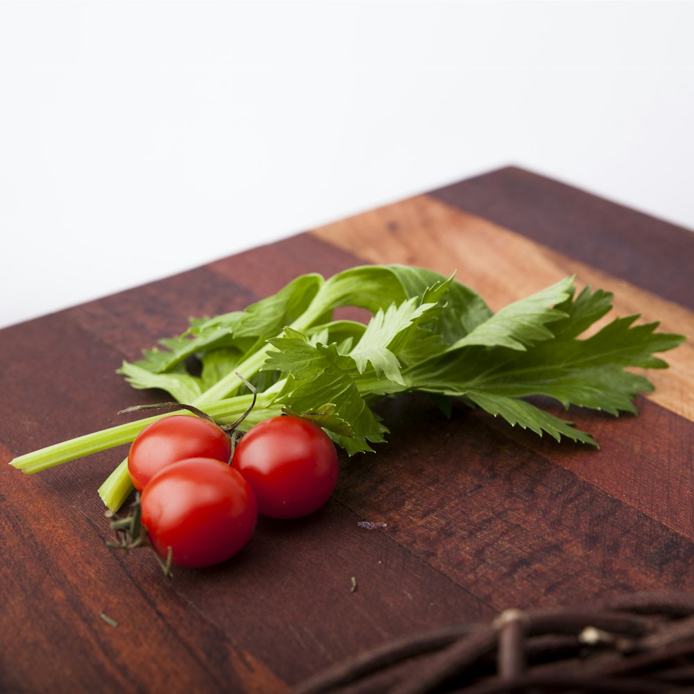 three red tomatoes near parsley