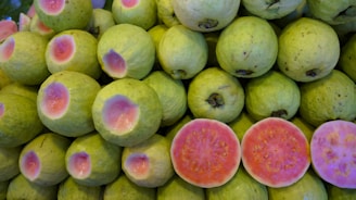 Close-up of vibrant guava sweets arranged on rustic wooden board.