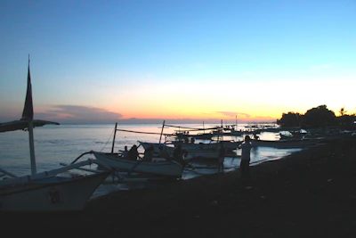 Sunset view over the historic island of Gorée with fishermen preparing their boats.
