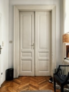 Interior shot showing a white paneled door with elegant molding and polished chrome knob.