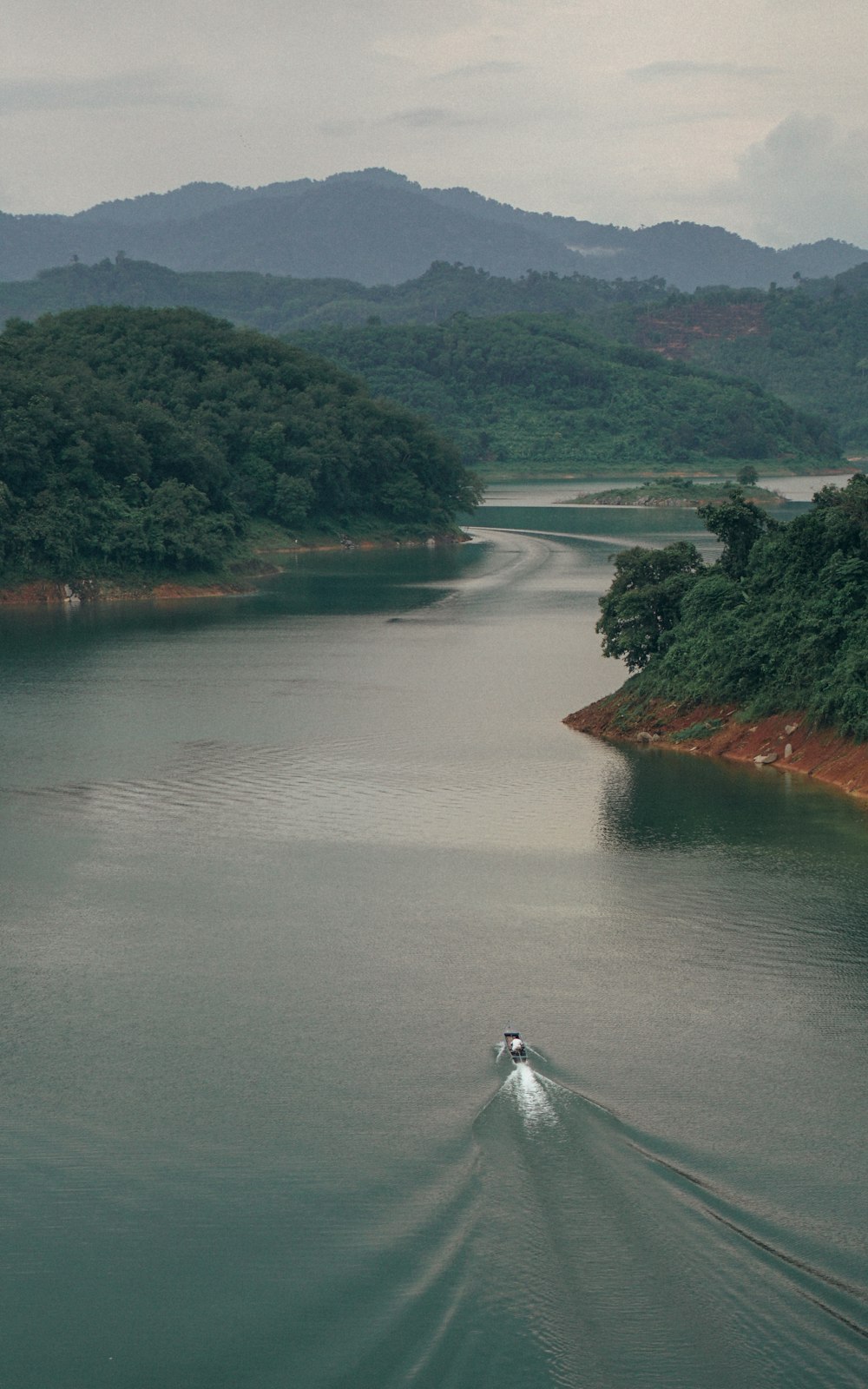 Bateau sur plan d’eau calme entre les arbres