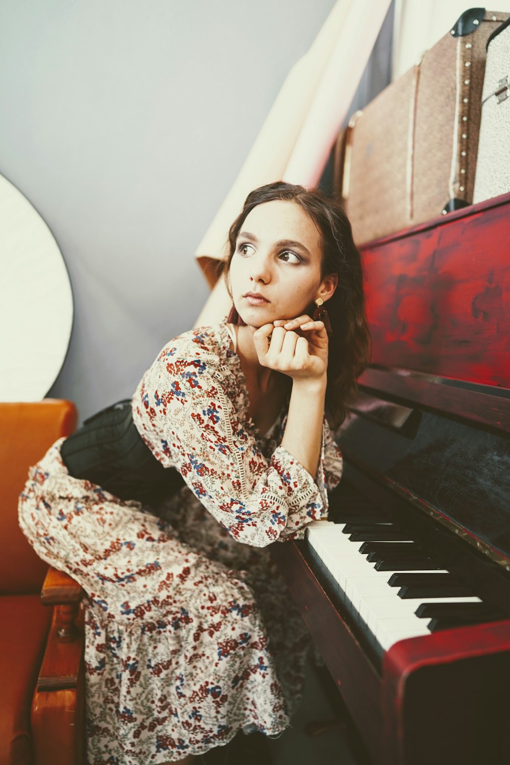 donna che si appoggia al pianoforte rosso e grigio