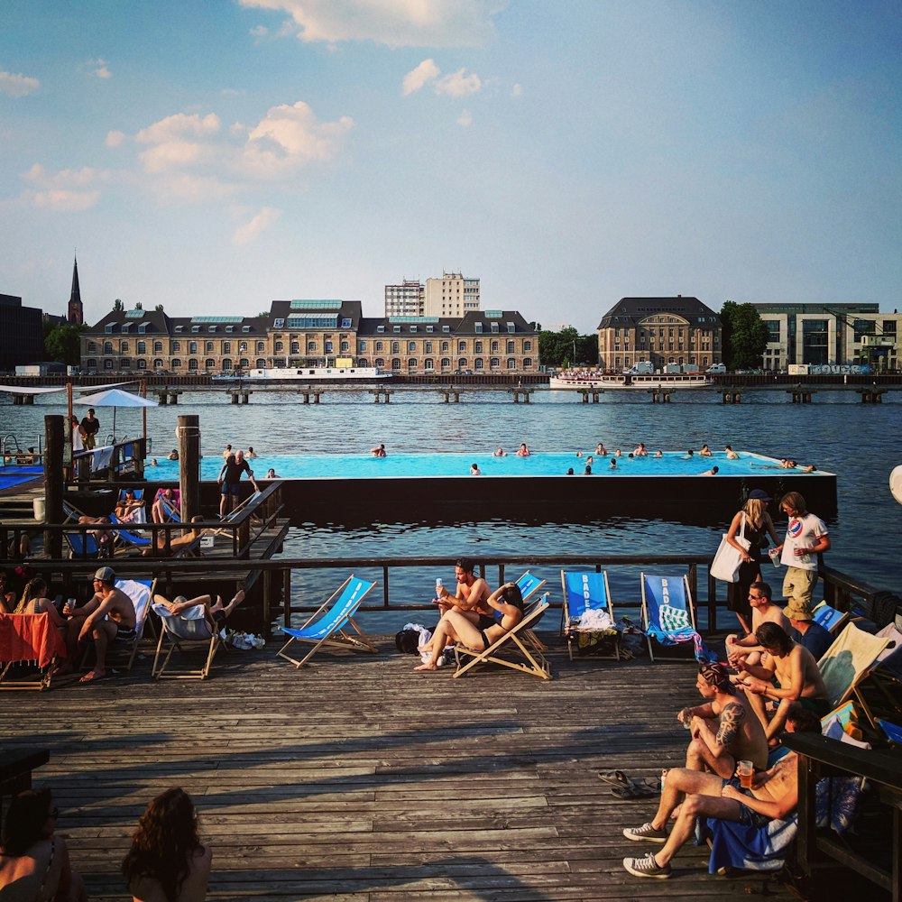 people on brown wooden floor near body of water