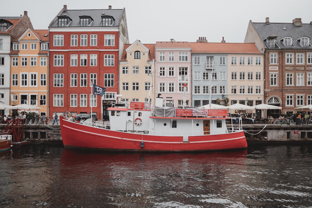 white and orange boat on water near buildings