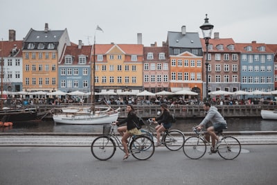 three people riding bicycles denmark teams background