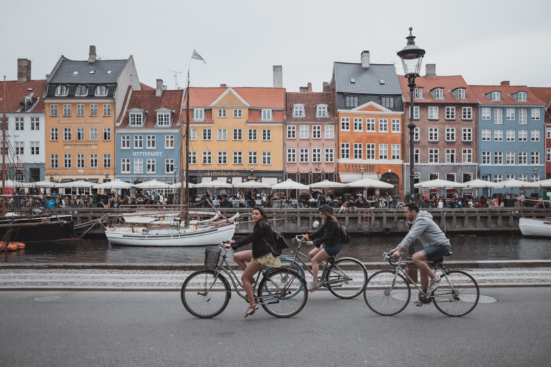 three people riding bicycles, Tourists biking at Nyhavn, Copenhagen.</p></figure><p>www.febiyan.com