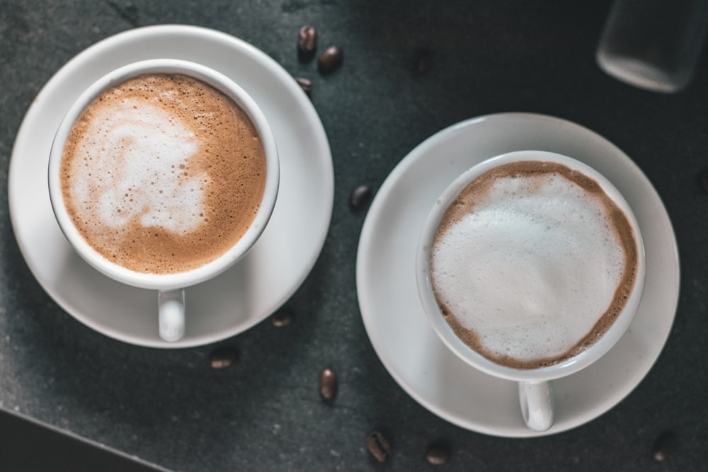 two filled coffee mugs with saucers