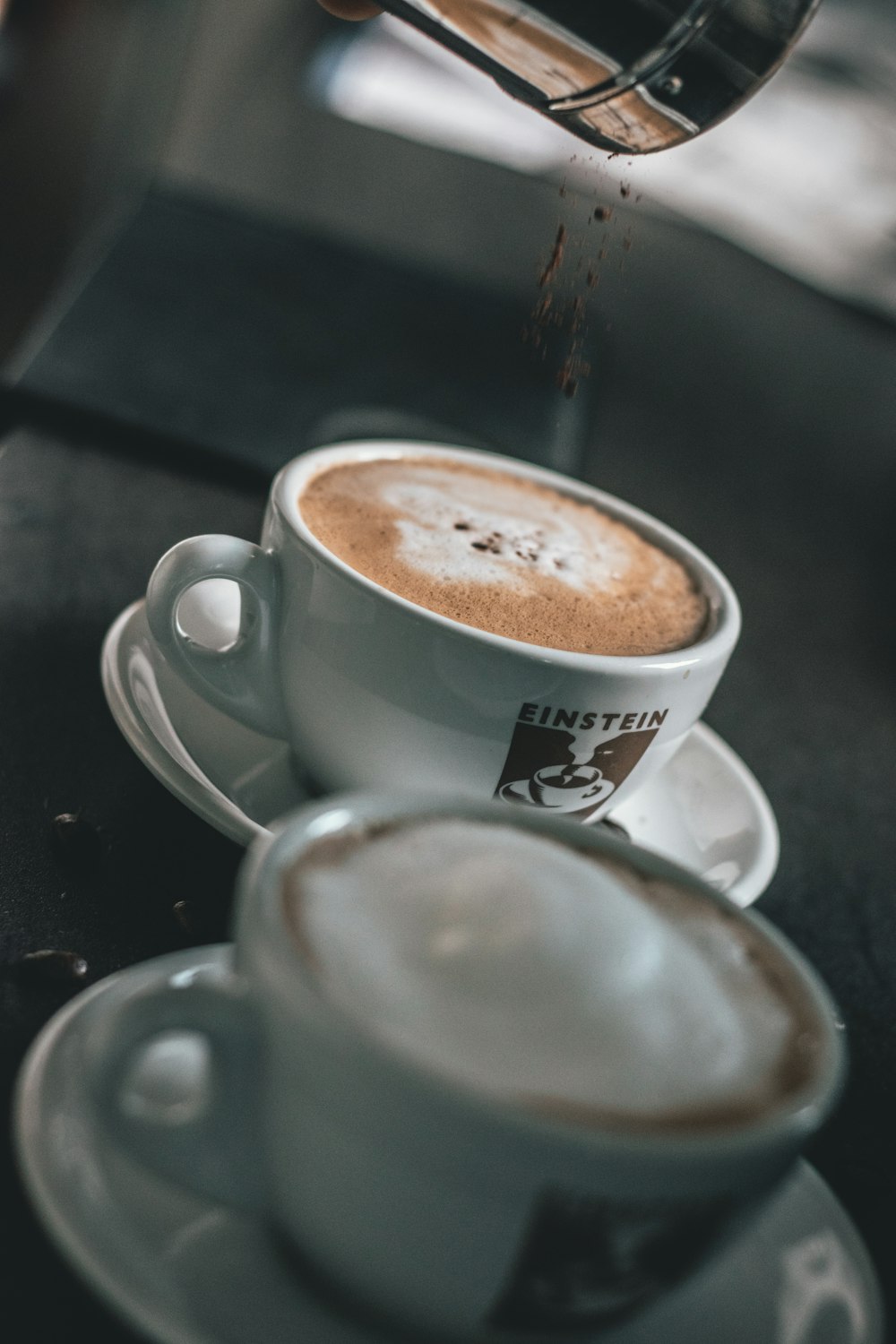 two mugs filled with coffee on saucers