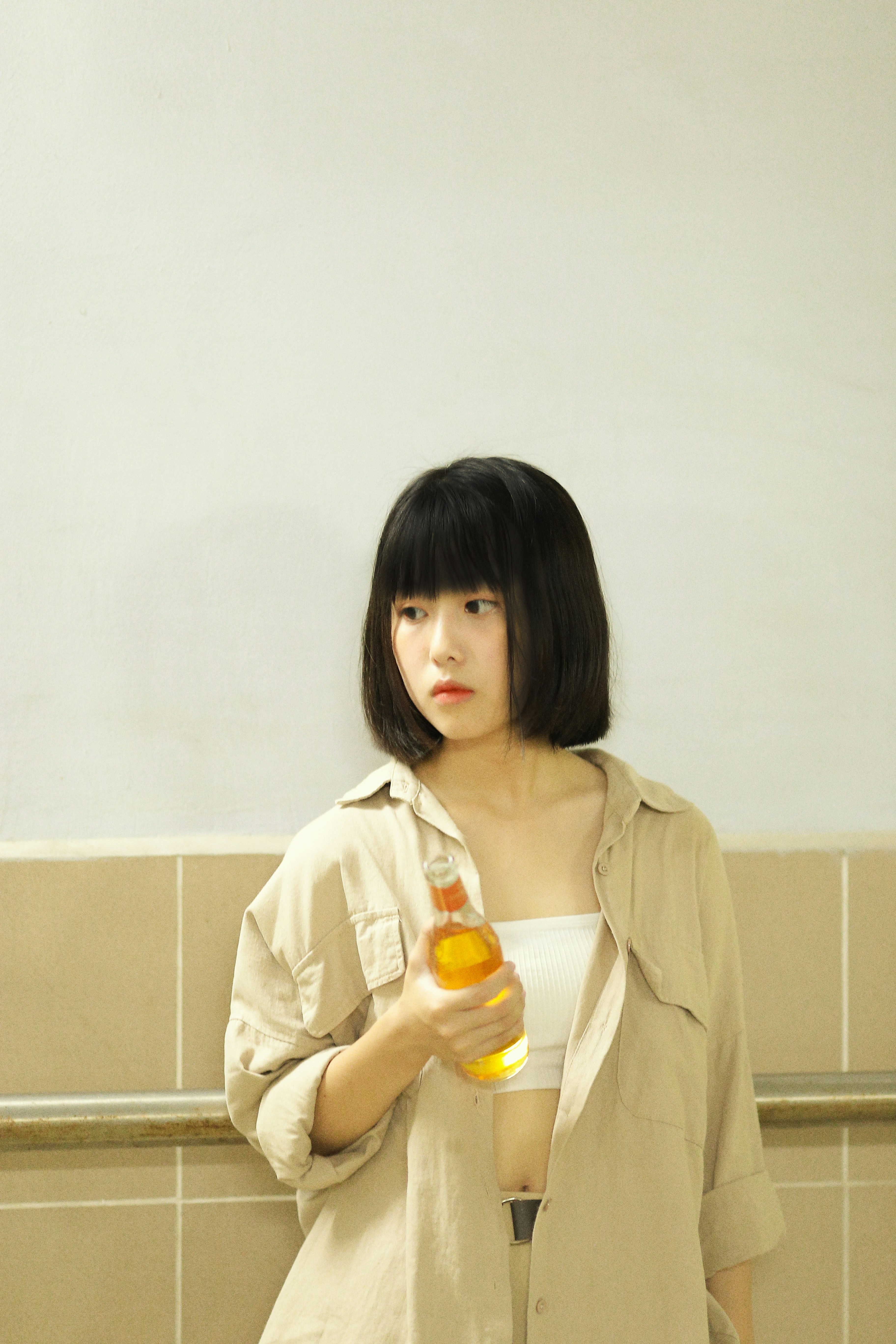 woman wearing brown blouse holding bottle