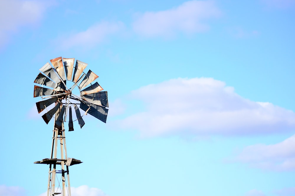 Braune und graue Windmühle unter blau-weißem Himmel