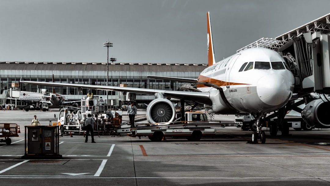 white and orange airplane landing and people going out from airplane,