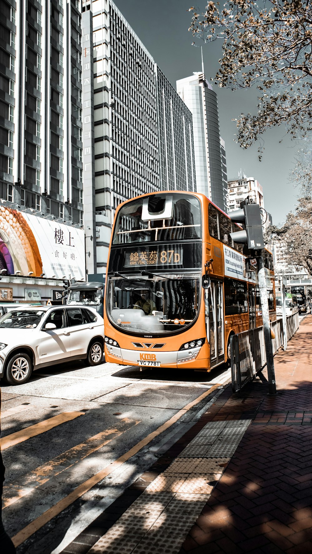 orange double decker bus running near sidewalk