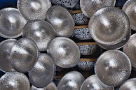 Close-up of polished stainless steel plates and bowls stacked elegantly.