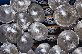 Close-up of polished stainless steel plates and bowls stacked elegantly.