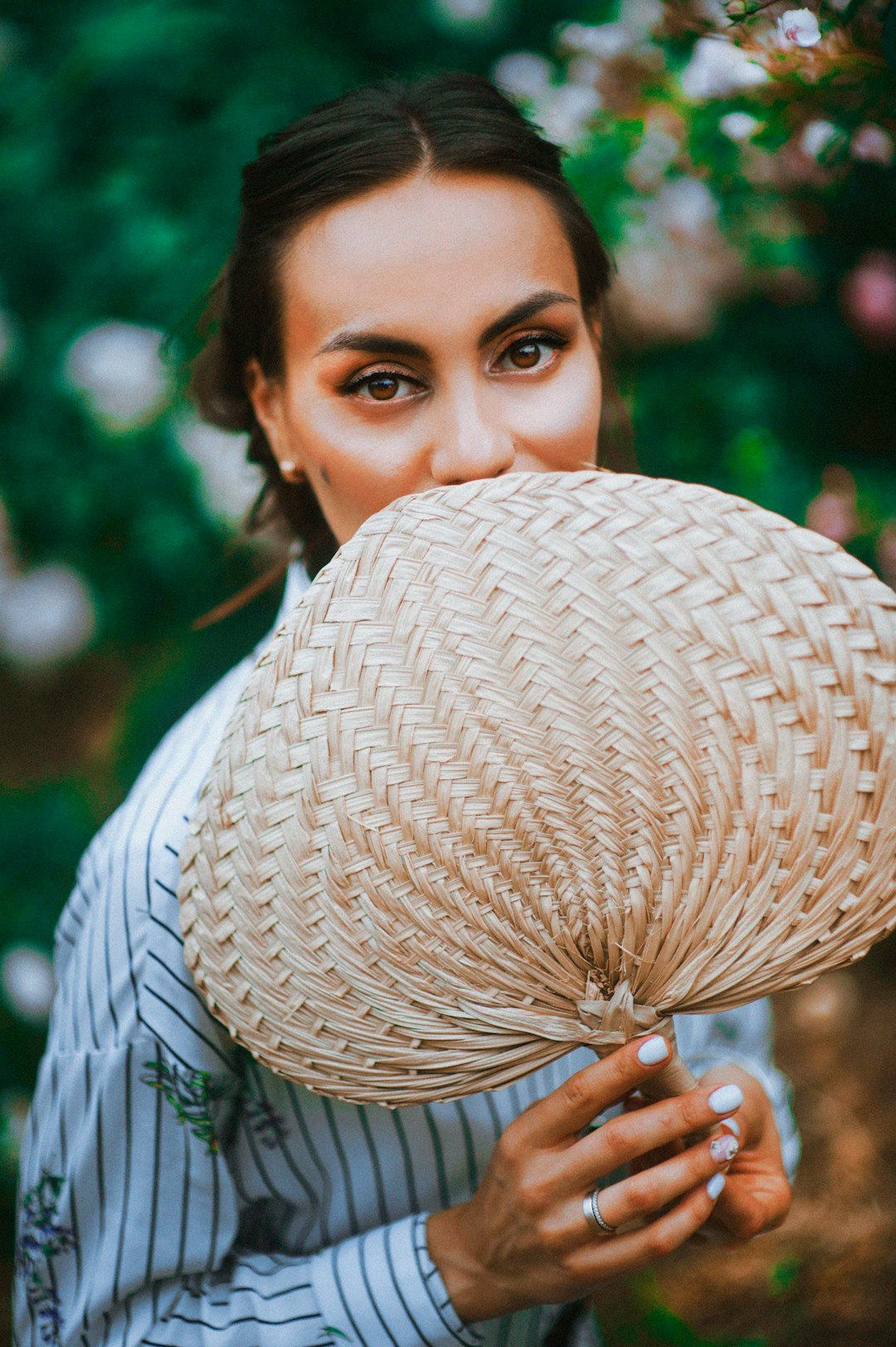 woman holding brown hand fan