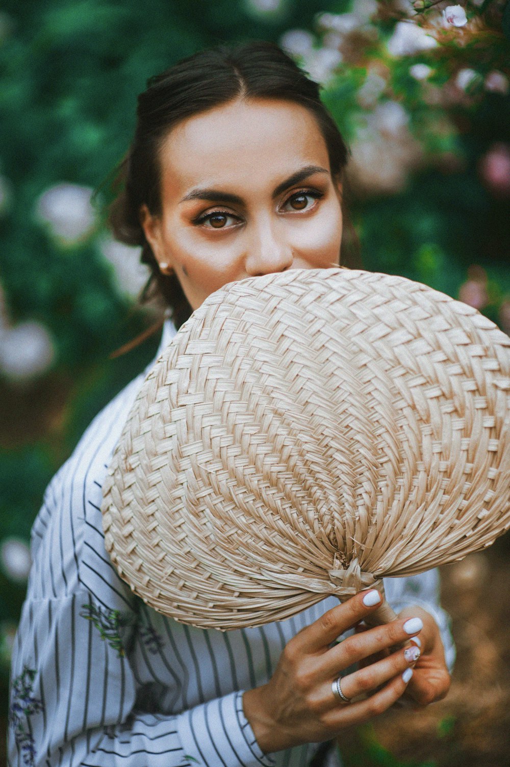 woman holding brown hand fan