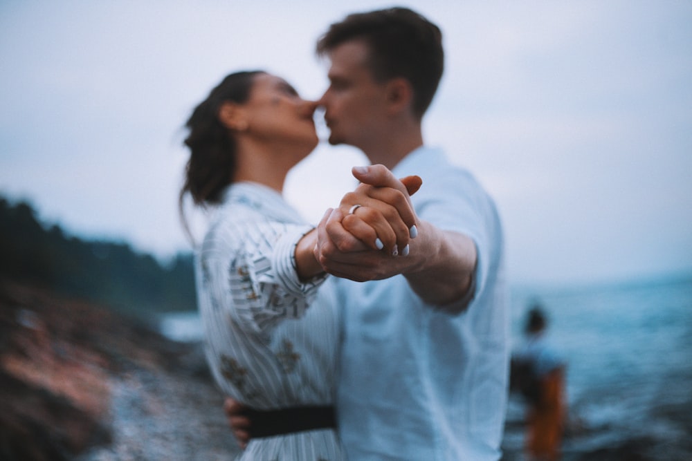 man and woman dancing on beach