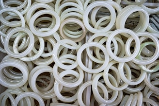 Elegant jade bracelets stacked on a wooden display with soft shadows