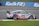 A race car with the number 33 and sporting FS Global Logistics branding speeds along a racetrack. The car is painted in blue, white, and red. The background shows a Kwik Fit advertisement banner next to a grassy area.