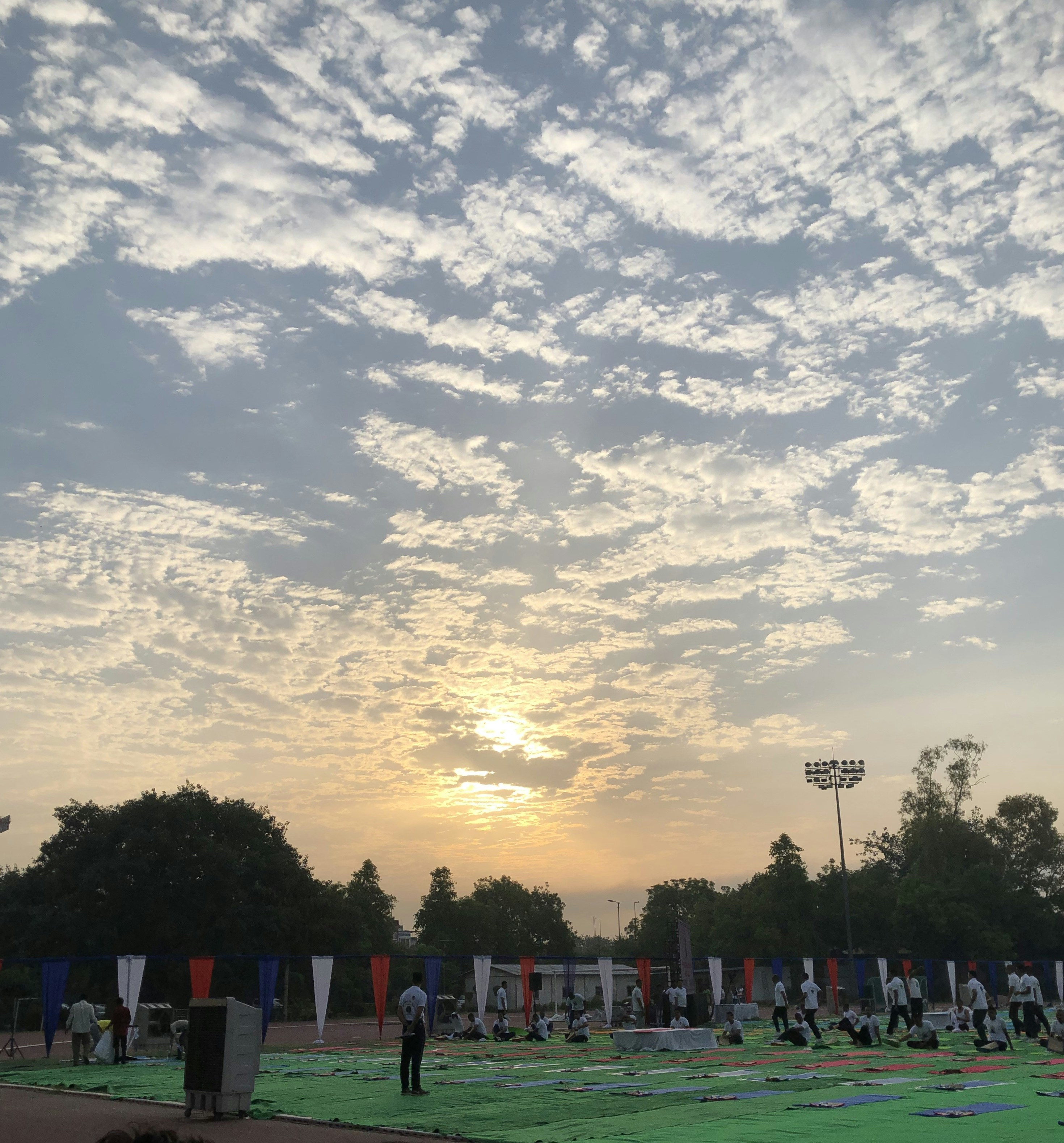 Community yoga session at sunrise, participants in peaceful outdoor setting