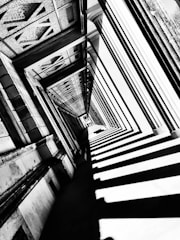 An artistic black and white photo of an old architectural detail with strong shadows.