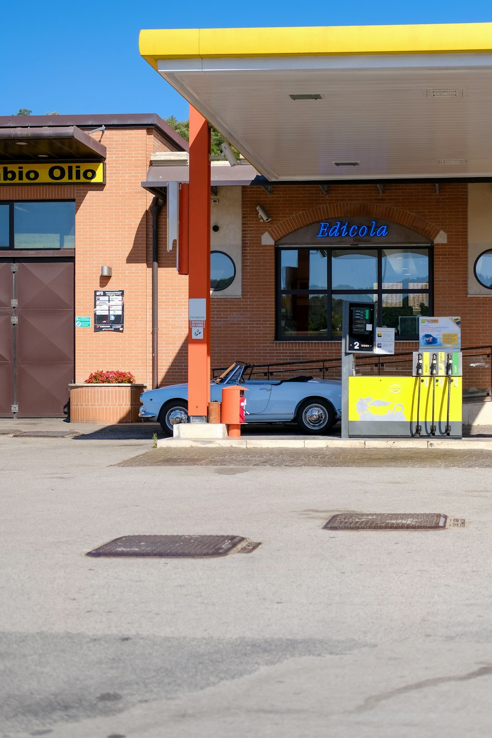 white convertible on gasoline station