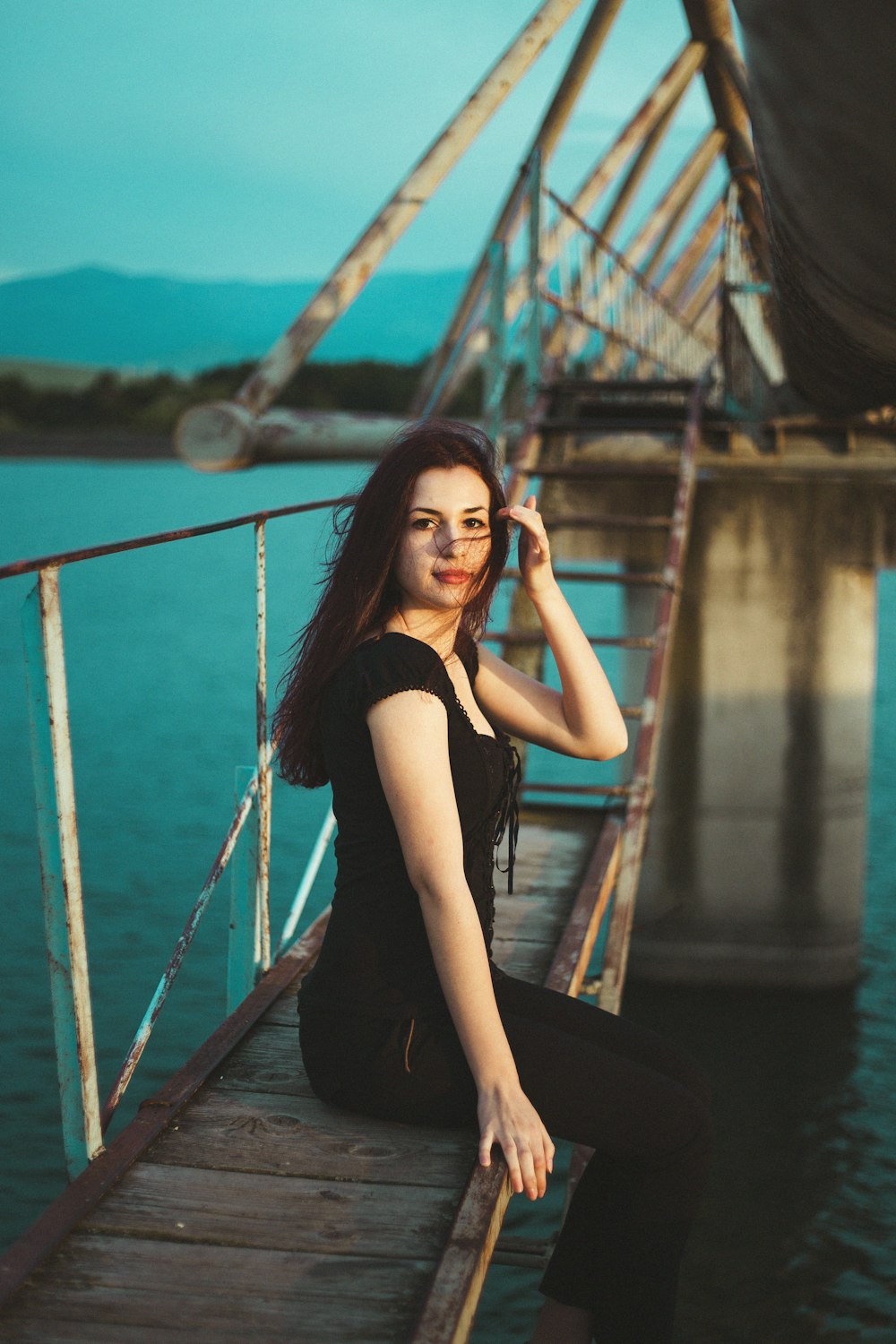 woman sitting on bridge