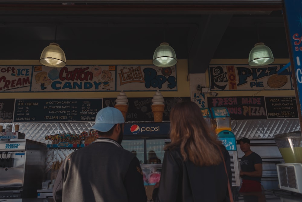 man and woman standing in front of kiosk