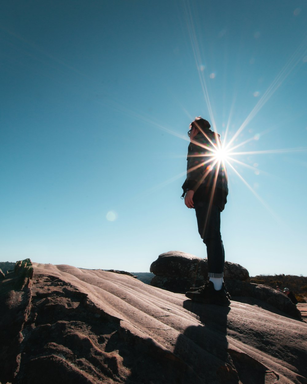 man wearing blue jeans on brown rock