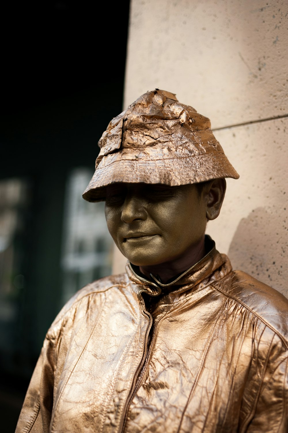 close-up photography of man standing beside brown wall