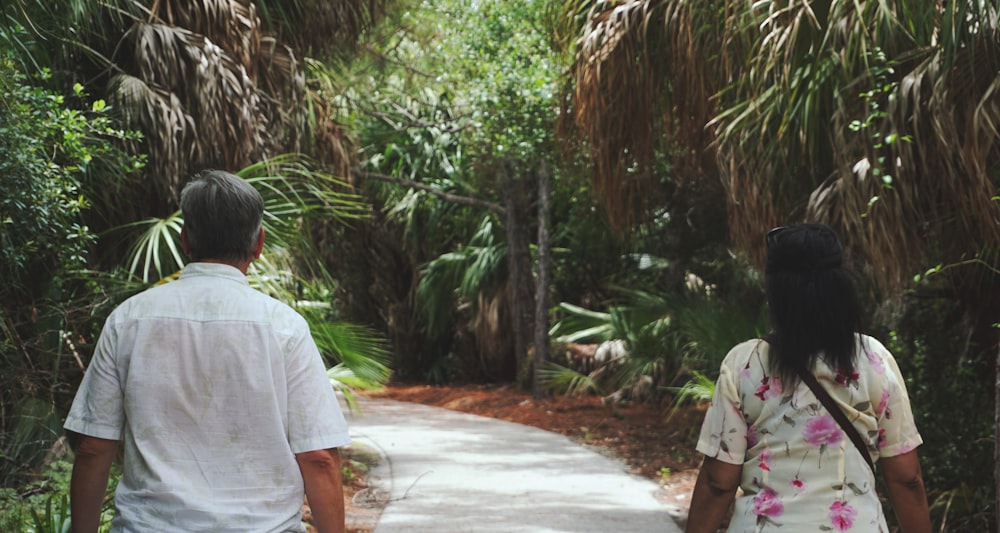 two people walking between trees