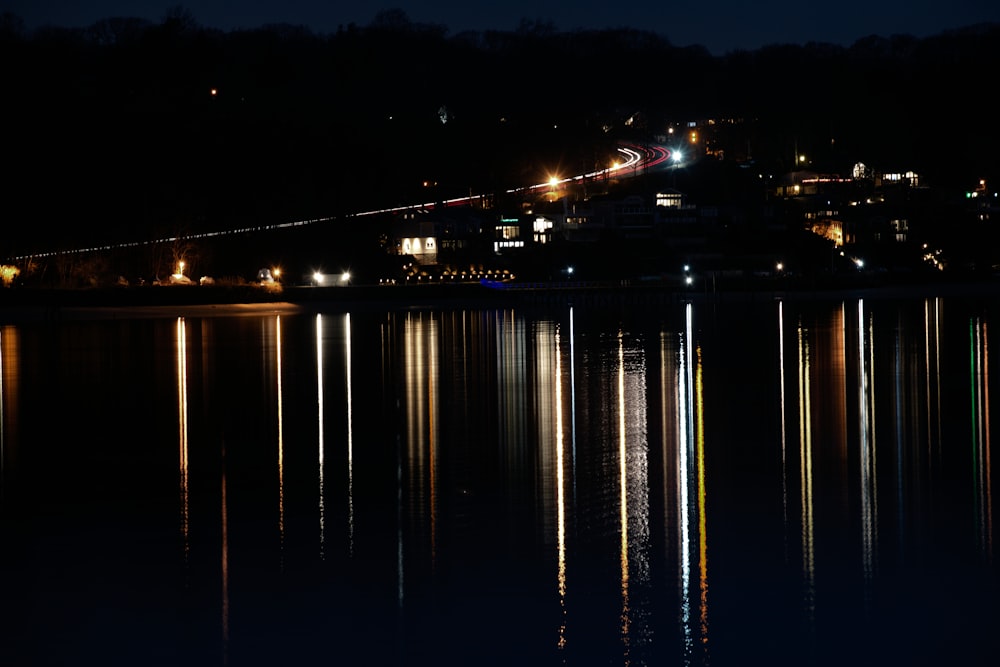 a body of water at night with lights reflecting off the water