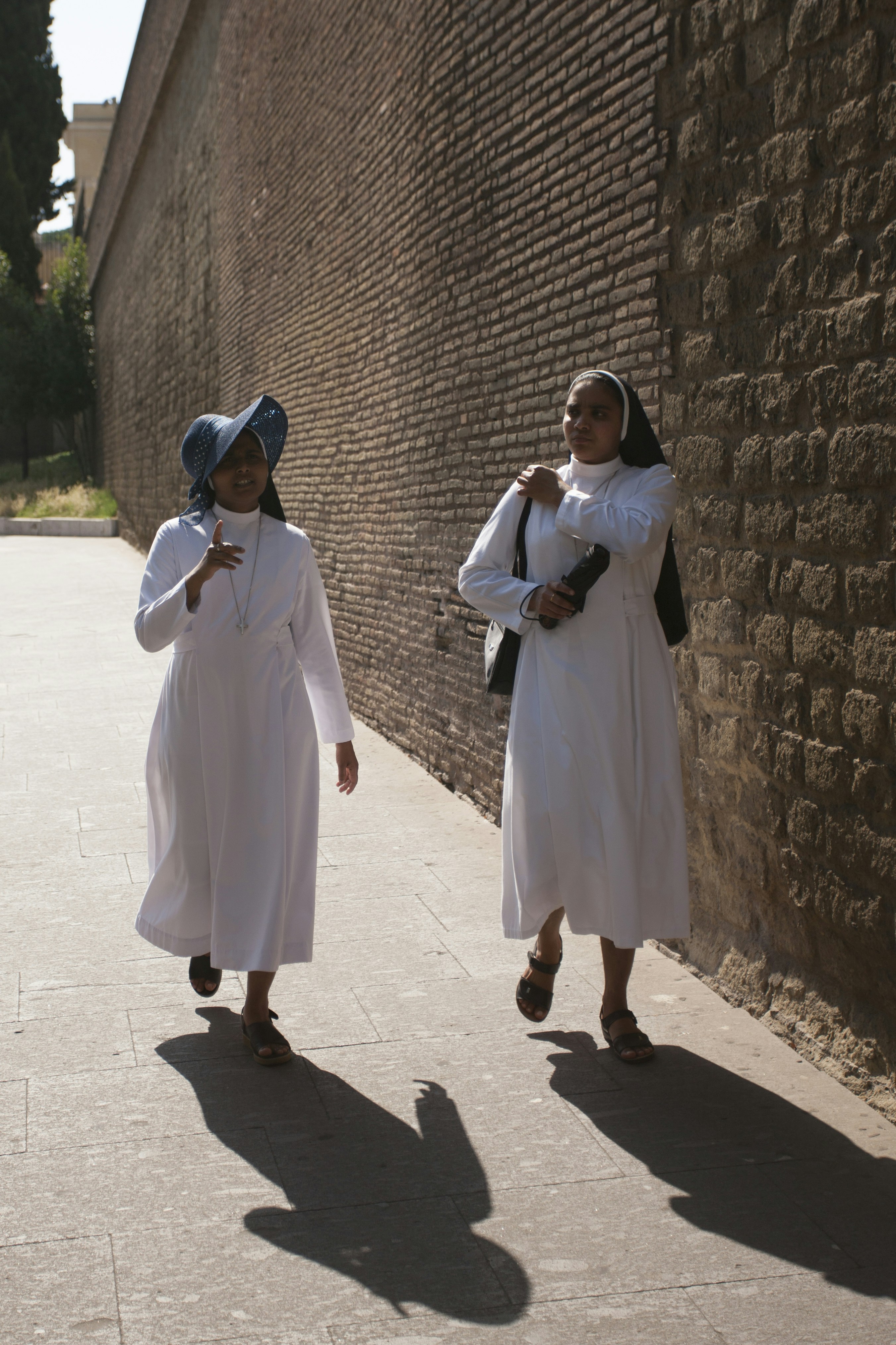 two nun walking near wall