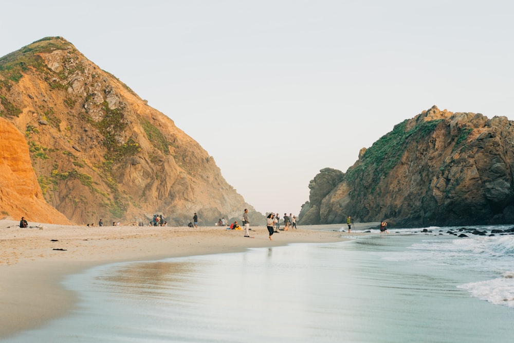 mountain near shore with people during daytime