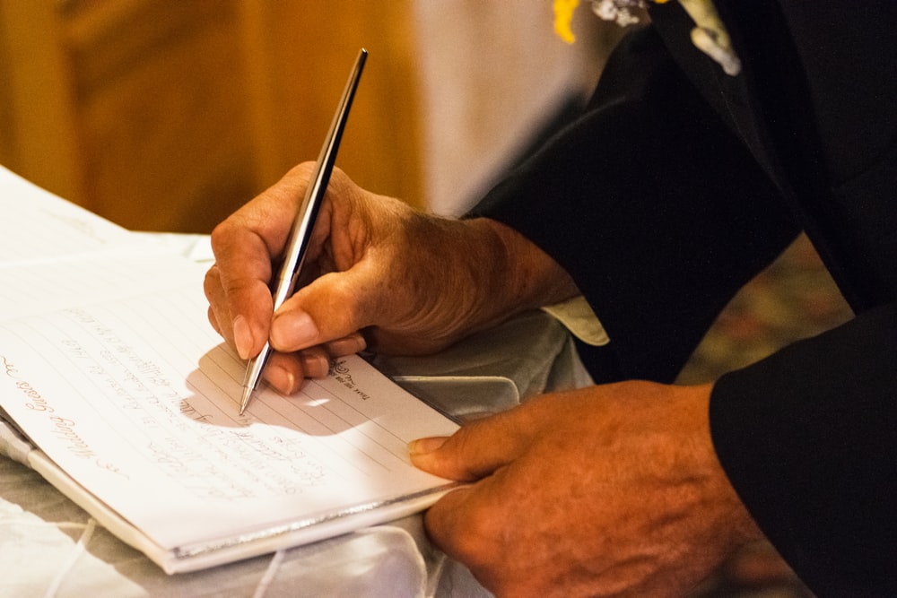 person writing on notebook