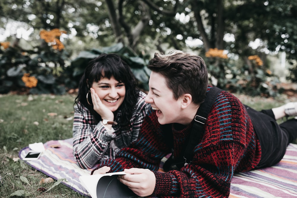 man and woman lying on textile on ground during daytime